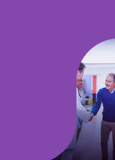 A patient shakes hands with his healthcare provider