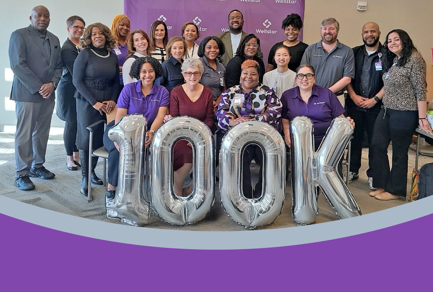 Photo of team with balloons reading "100K"