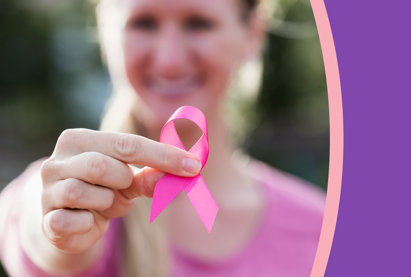 Think PINK: Raise Your Breast Cancer IQ A woman holds a pink breast cancer awareness ribbon in her fingers