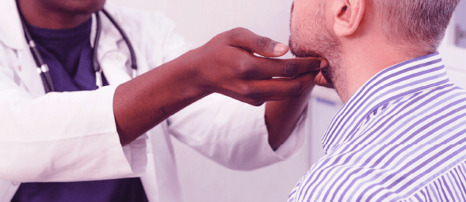 A head and neck cancer specialist examines a patient's neck.