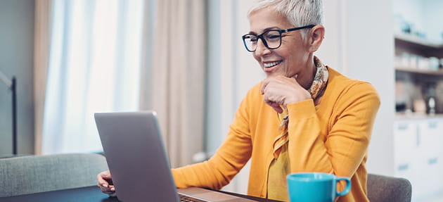 Woman sitting at a desk looking at her laptop